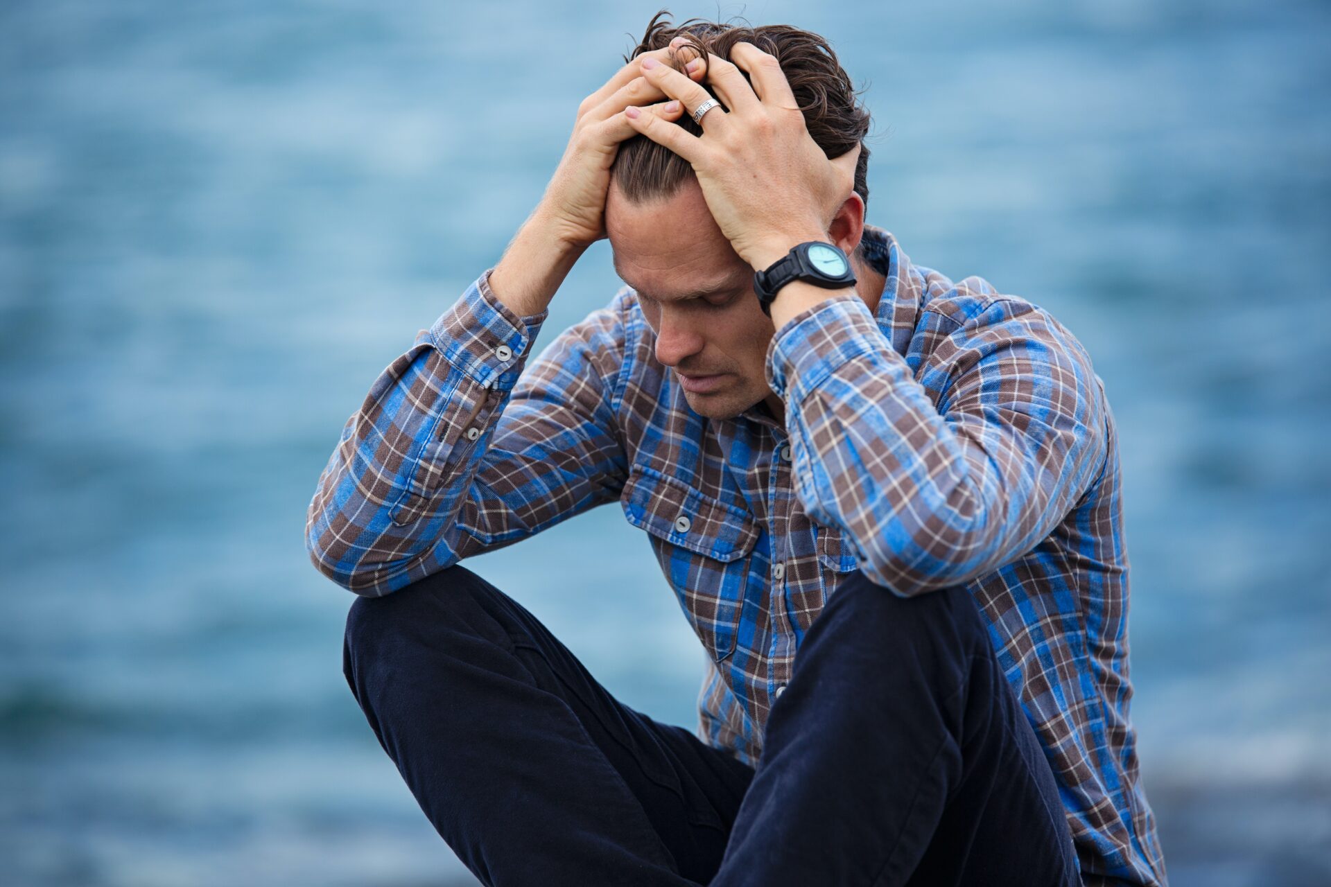 Young man in blue plaid shirt looking overwhelmed